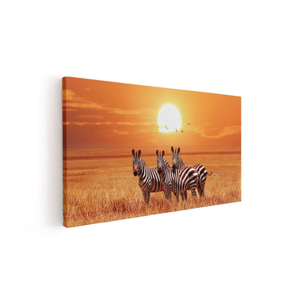 Canvas schilderij vooraanzicht Drie Zebra's Bij Zonsondergang