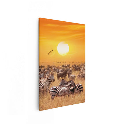 Canvas schilderij vooraanzicht Kudde Zebra's Bij Een Oranje Zonsondergang