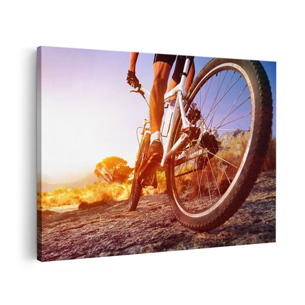 Canvas schilderij vooraanzicht Mountainbike Fietser op Stenen bij Zonsopgang