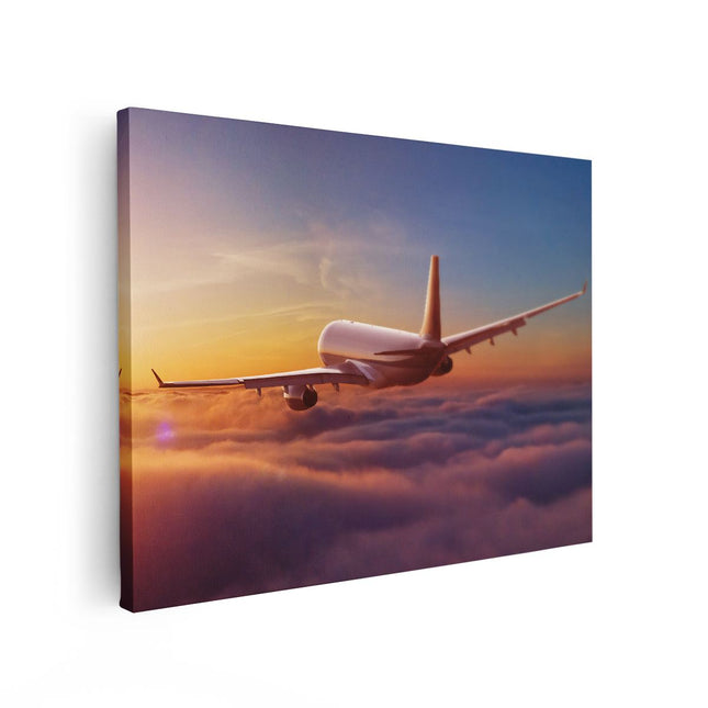 Canvas Schilderij Vooraanzicht Vliegtuig In De Wolken Bij Zonsondergang
