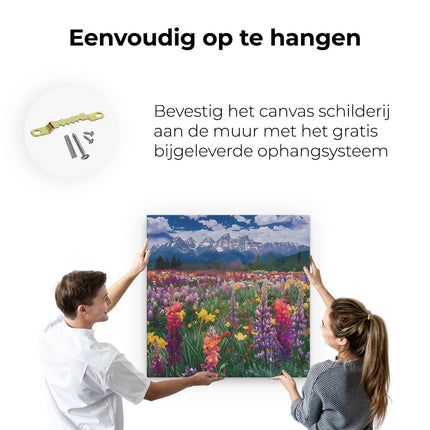 Canvas schilderij ophangen Kleurrijke Bloemen in een Veld met Bergen op de Achtergrond