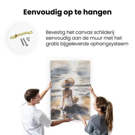 Canvas schilderij ophangen Vrouw Zittend op het Strand met een Strohoed