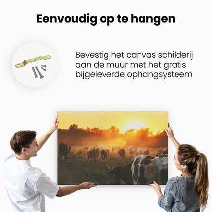 Canvas schilderij ophangen Kudde Koeien In Weiland Bij Zonsondergang