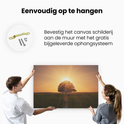 Canvas schilderij ophangen Zonsondergang Achter Een Grote Boom