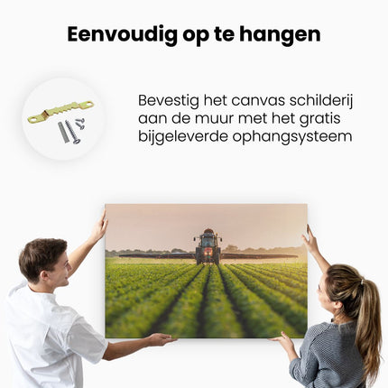 Canvas schilderij ophangen Rode Tractor op het Veld aan het Sproeien