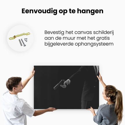 Canvas schilderij ophangen Man met een Pistool in zijn Handen