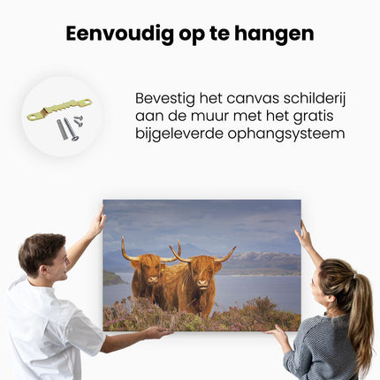 Canvas schilderij ophangen Twee Schotse Hooglanders bij een Meer