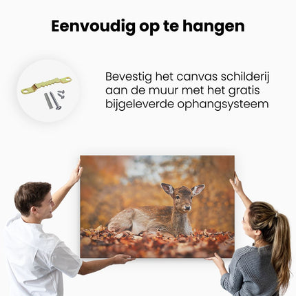 Canvas schilderij ophangen Baby Hert tussen de Bladeren in een Herfst Bos