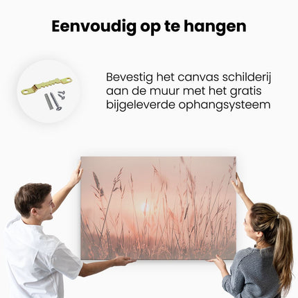Canvas schilderij ophangen De Zon gaat onder boven een Grasveld