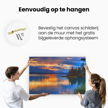 Canvas schilderij ophangen De Zon gaat onder boven een Meer met Bergen op de Achtergrond