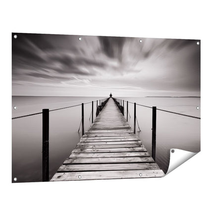 Tuinposter vooraanzicht Persoon die op een Pier Staat onder een Bewolkte Hemel